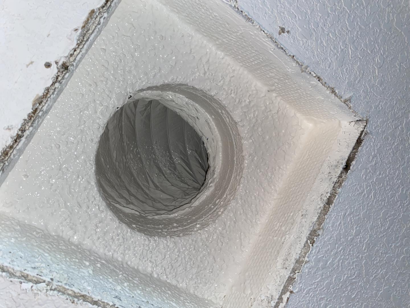 HVAC technician using HEPA-filtered vacuum equipment on a home air duct
